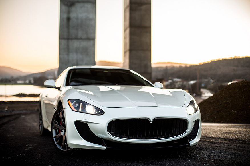 White coupe sport car standing on the road, front view.